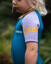 The C-Skins Girls NuWave C-Kid Baby Front Zip Shorty Wetsuit in Steel Blue & Lilac